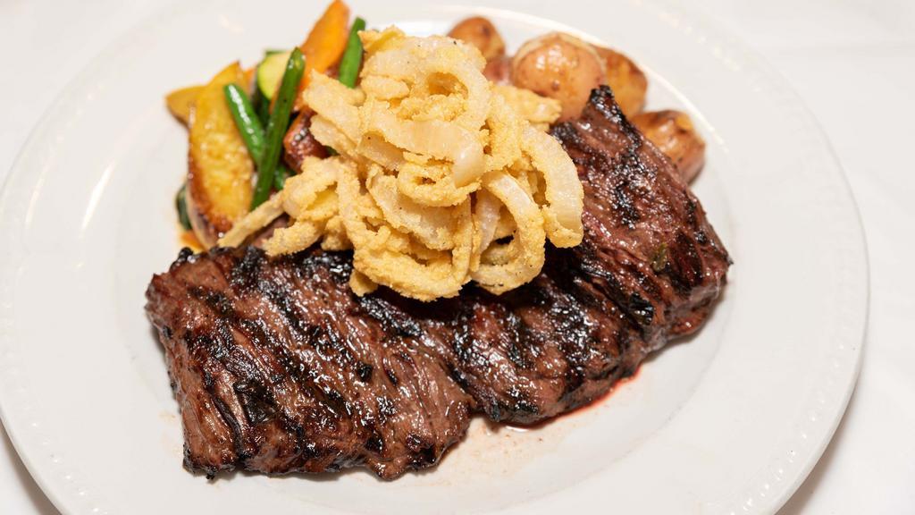 Skirt Steak · Grilled 12oz skirt steak, topped with crispy fried onions. served with roasted potatoes & a vegetable trio