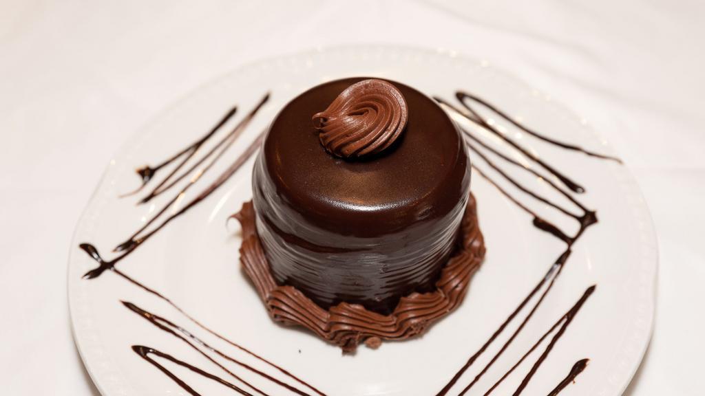Death By Chocolate · An individual sized chocolate cake with each layer slathered. wtih chocolate butter cream covered in hot fudge.