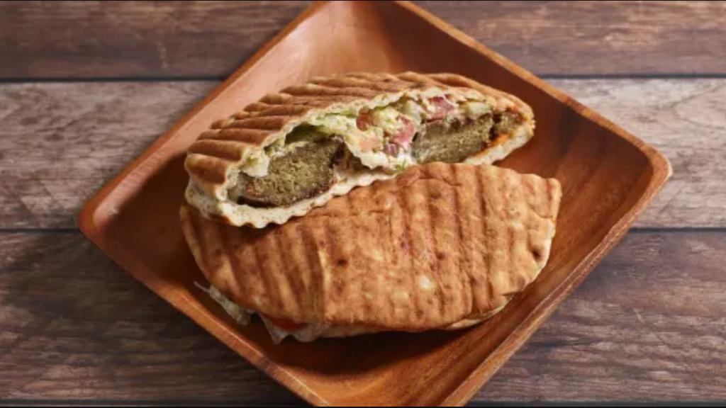 Classic Falafel Sandwich · Crispy falafels, salad, house-made white sauce, and hot sauce served in warm pita bread.
