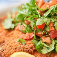 Chicken Milanese · Crispy fried chicken breast with tomato arugula salad.