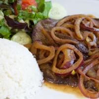 Bistec Encebollado · Grilled steak with sautéed onions and peppers served with white rice and beans.