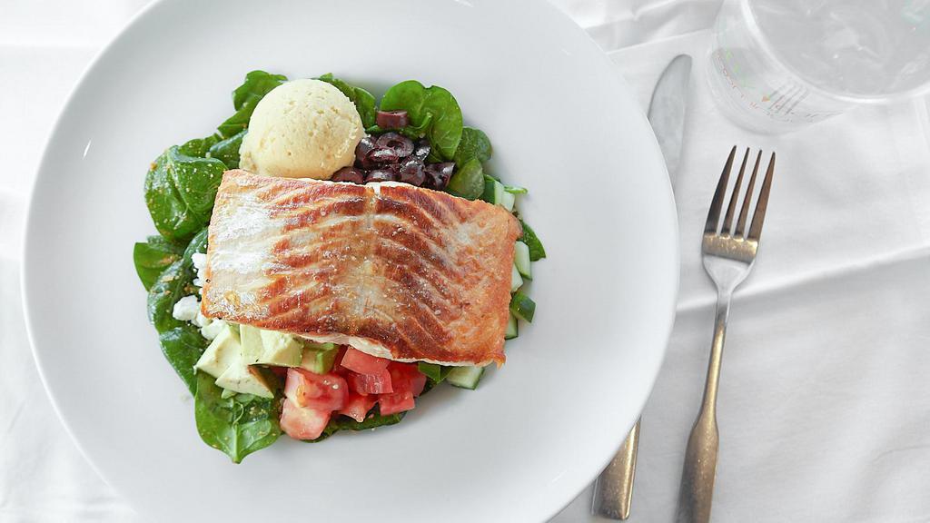 Mediterranean Quinoa Bowl · Grilled Atlantic salmon, white quinoa, spinach, tomatoes, cucumbers, kalamata olives, avocado, feta cheese, hummus, roasted red pepper vinaigrette.