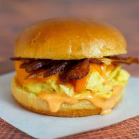 Bacon, Egg And Cheddar Sandwich · 2 scrambled eggs, melted Cheddar cheese, smoked bacon, and Sriracha aioli on a  brioche bun