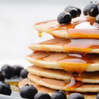 Fluffy Blueberry Pancakes · Fluffy buttermilk pancakes covered with blueberries served with butter and syrup.