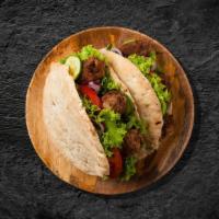 Shish Kofte Sandwich Wrap · Pita wrap filled with grilled lamb, diced onions, tomatoes, parsley, hummus and pickles.