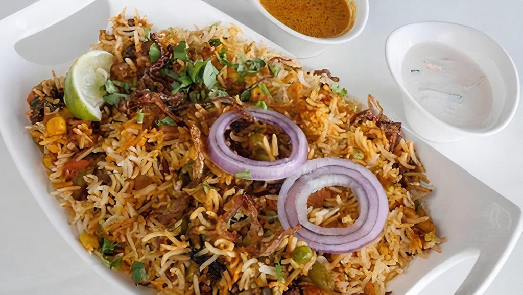 Vegetable Biryani · Basmati rice cooked with vegetable, blendedwith herbs, and spices, then garnished with onion and lemon. served with yogurt raitha and pepper gravy.