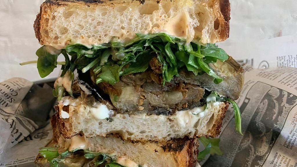 Grilled Eggplant Sandwich · Grilled & roasted eggplant slices, whipped feta, harissa aioli, fried capers, baby arugula on Filone bread.