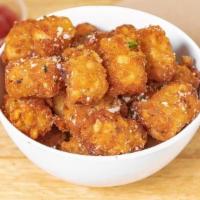 Truffle Tots · Crispy, golden tater tots tossed in truffle zest and grated parmesan cheese.