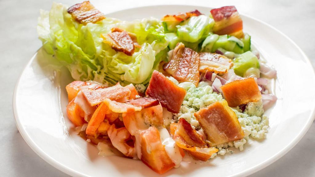 Wedge Salad · Iceberg lettuce, organic tomato, red onion, nueske's thick cut slab bacon and blue cheese.