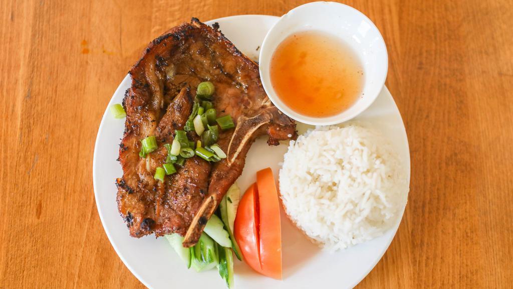 Pork Chop Rice Bowl · Grilled pork chop on rice served with slice cucumber and tomatoes.
