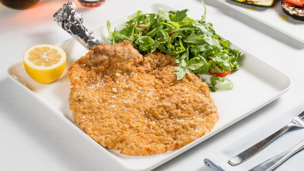 Cotoletta Alla Milanese · Pounded thin veal chop “Milanese style” with arugula, grape tomatoes, and lemon vinaigrette.