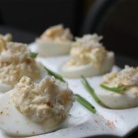 Crabby Eggs · Deviled eggs with crab meat, old bay, lemon, and chives.