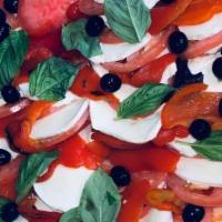 Caprese Salad · Beefsteak tomatoes, fresh mozzarella, basil, extra virgin, and balsamic.