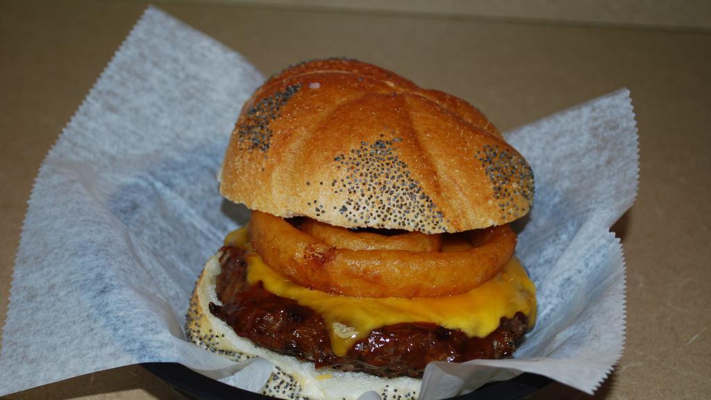 Bbq Burger · 8 oz. Burger with BBQ Sauce, Cheddar Cheese, topped with Onion Rings on a Seeded Roll.