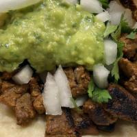 Taco Carne Asada · Grilled beef, guacamole, onion, and cilantro.