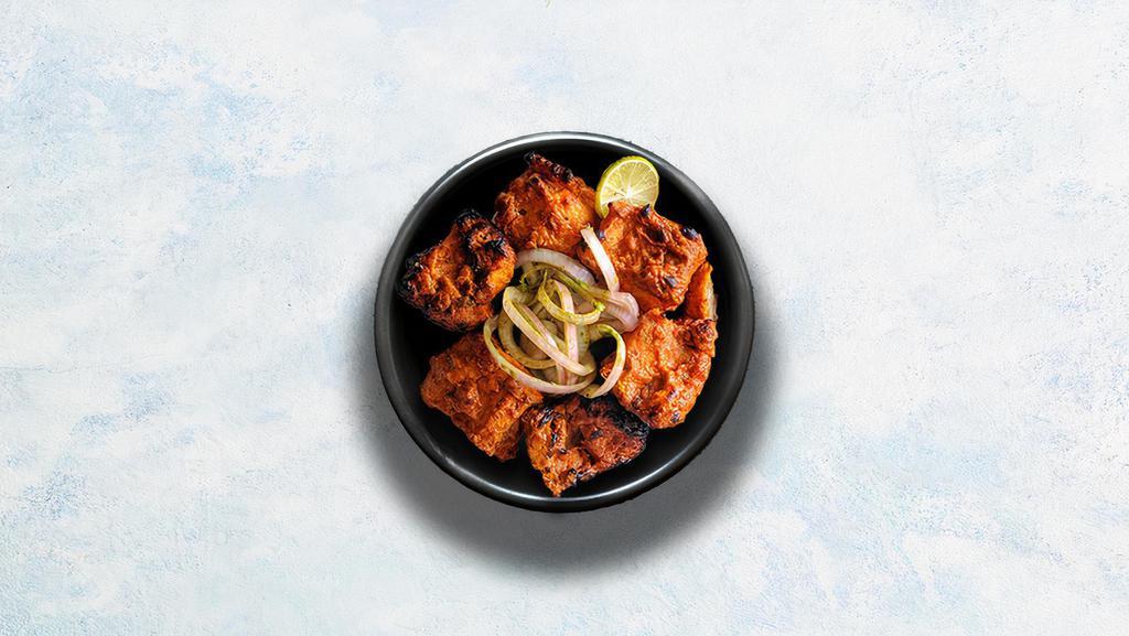 Chicken Tikka · Tender pieces of chicken marinated in yogurt, glazed in a traditional Indian clay oven. Served with our signature mint relish.