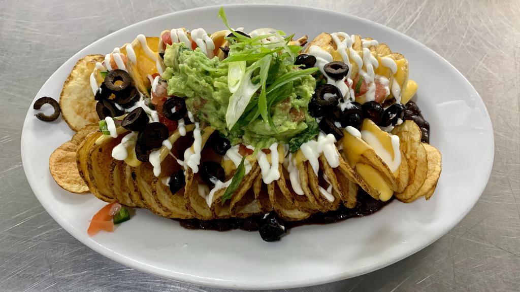 Twisted Nachos · Crispy twisted potatoes with melted cheddar cheese, black beans, tomatoes, olives, sour cream & guacamole.