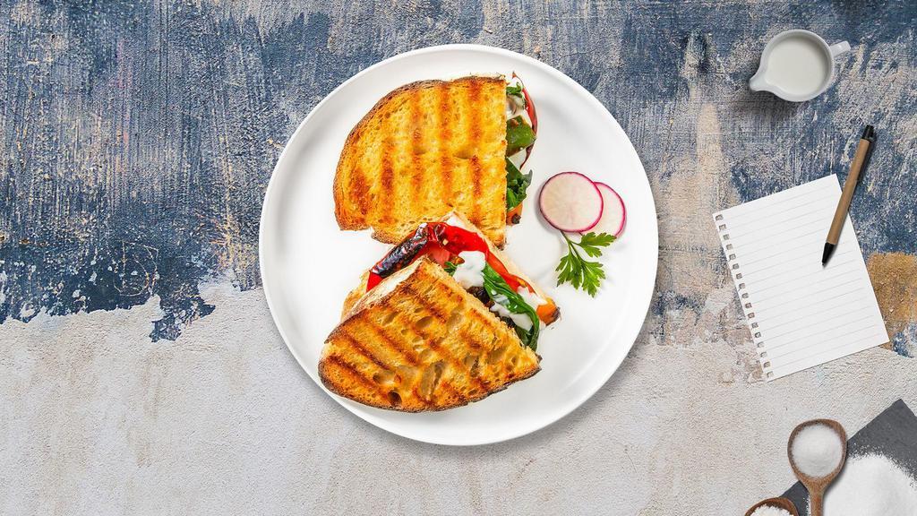 The Desica Panini · Breaded eggplant, roasted peppers, mozzarella, and caponata on freshly baked bread. Served with a salad.