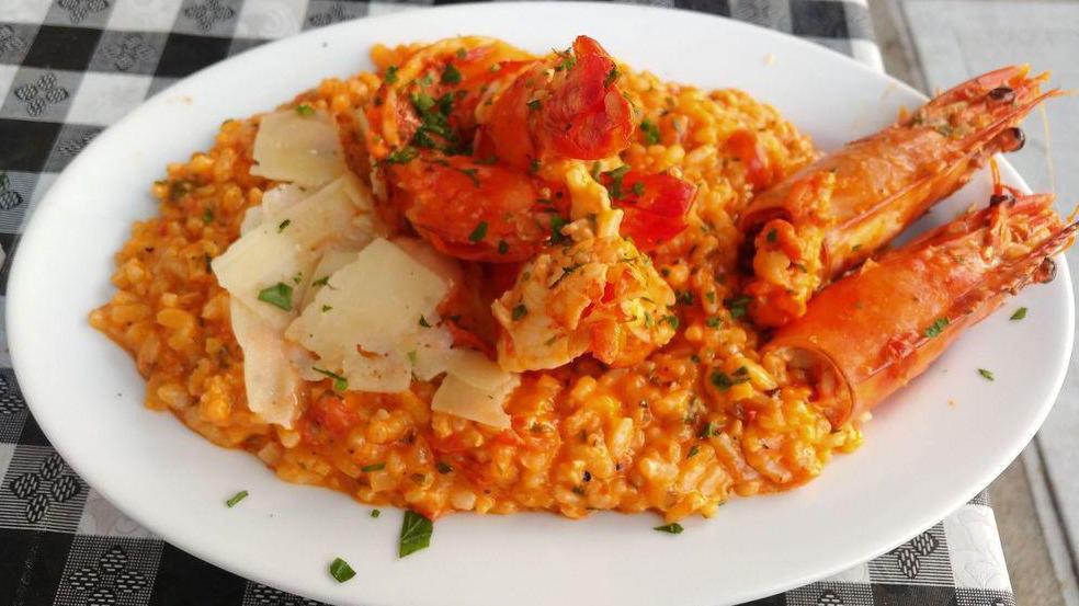 Γαρίδες Σαντορίνη / Shrimp Santorini · Sautéed shrimp with ouzo, tomato, onions, garlic, & feta served over rice.