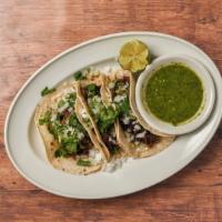 Tacos De Suadero · Thin cut brisket seasoned with garlic, black peppers, and onions. Topped with cilantro and c...