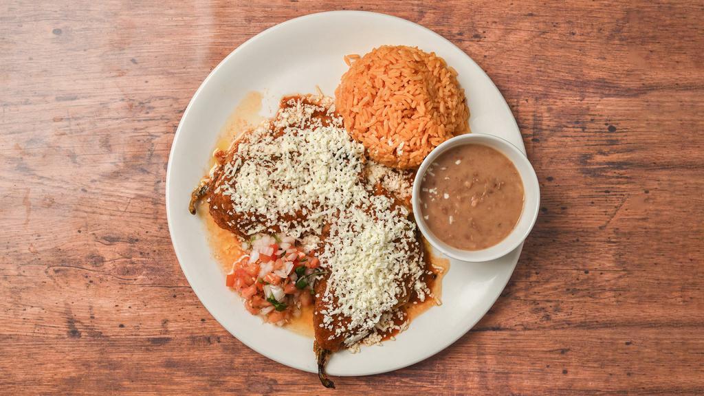 Chile Poblano Relleno · Two large green poblano peppers stuffed with chicken and topped with ranchero sauce and shredded Mexican cheese.