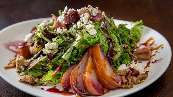 Poached Pear Salad · Baby mixed greens, caramelized walnuts and poached Williams pears finished with barolo wine vinegar and topped with crumbled goat cheese and balsamic vinegar reduction.