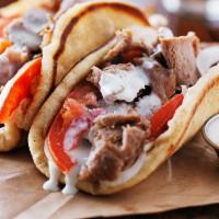 Gyro · Slow roasted spiced meat dressed with lettuce, tomato, onion, and tzatziki sauce on pita bre...