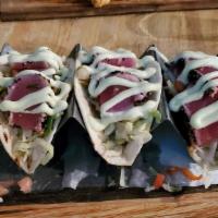 Tuna Tacos · Sesame crusted ahi tuna, Asian slaw wasabi infused pico de gallo, corn and black bean relish.