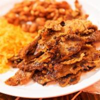 Chuleta Ahumada · Sliced grilled smoked pork chop. Served with Mexican yellow rice and pinto beans accompanied...