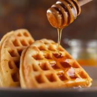 The Belgian Waffle · Golden Belgian waffle served with a side of maple syrup.