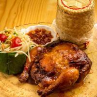 Esan Chicken · Grilled marinated hen with Thai spices, papaya salad, and sticky rice.
