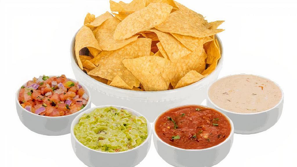 The Chips Spread · Includes a Large Bag of Freshly Fried Chips (12oz), 8oz of Freshly Prepared Guacamole, 8oz of Freshly Prepared Queso, and 2 of your favorite House Made Salsas, 8oz each.