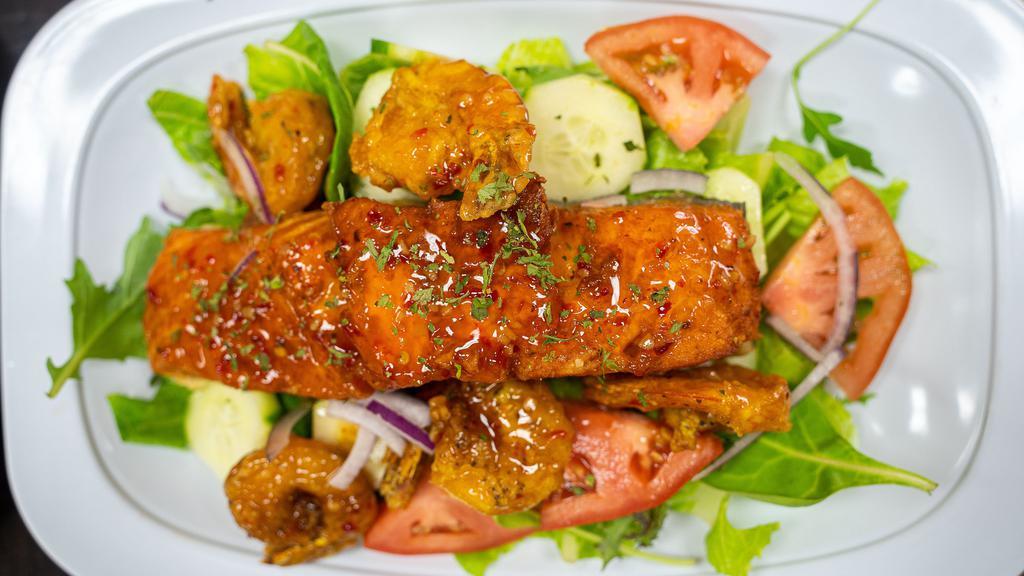Jerk Salmon Salad · Full serving of jerk salmon with lettuces, tomatoes, onion, carrots an cucumber.