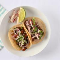 Pastor Tacos · Tacos served with soft onion and cilantro.