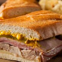 Sandwich Cubano With French Fries · Sandwich made with roasted pork, ham, pickles, and Swiss cheese on Cuban bread with French F...
