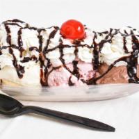 Banana Split · Three scoops of ice cream nestled between a fresh, split banana. Topped with chocolate sauce...