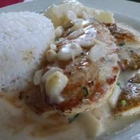 Pollo Al Ajillo · Chicken with garlic sauce. Served with rice and baked potatoes.