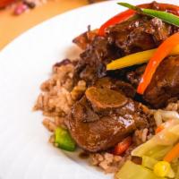Stew Chicken · Chicken braised in a dark sauce. Served with rice and peas or white rice, and steamed vegeta...