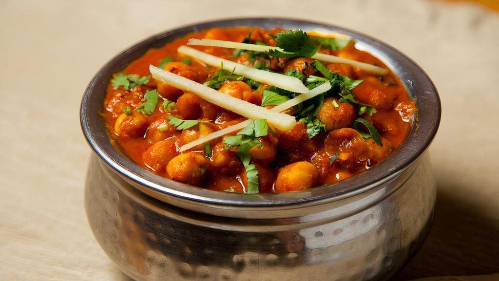 Chana Masala · Vegetarian, vegan, gluten free. Garbanzo/chickpea beans prepared with a blend of pomegranate seeds, dry mango, carom (ajwain), black peppercorns and garnished with & ginger juliennes.