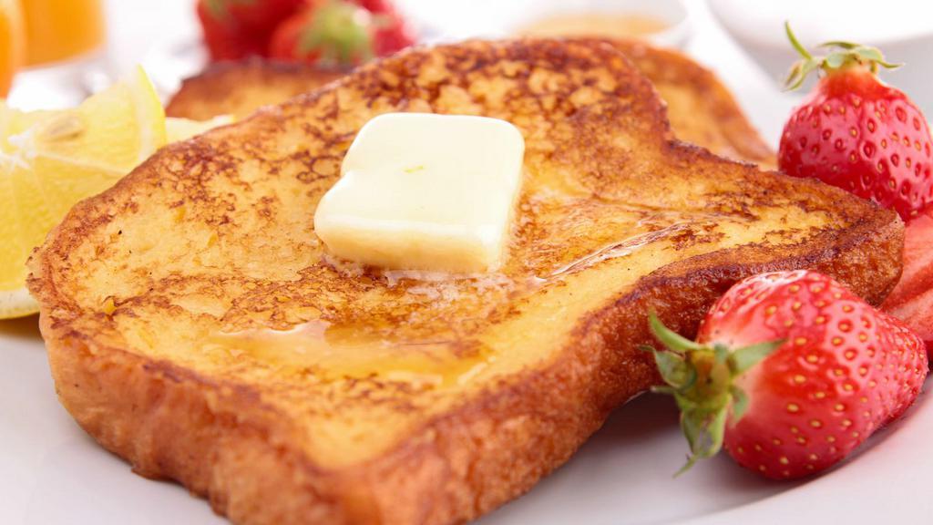 Strawberry French Toast · Sweet slices of French toast fresh off the griddle topped with strawberries and served with syrup.
