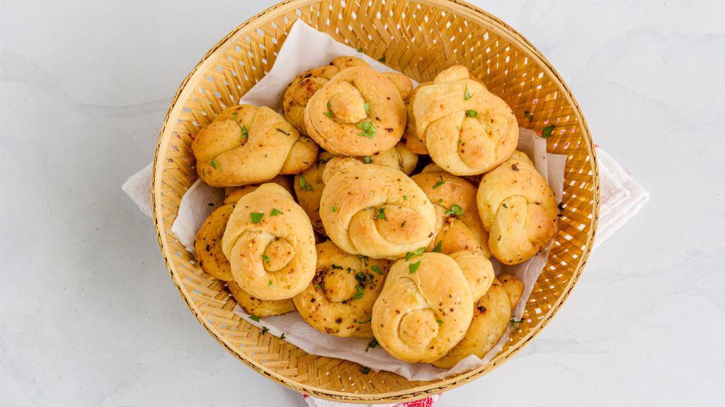 Garlic Knots · Five thinly knotted pizza dough rolls soaked in fresh garlic and olive oil.