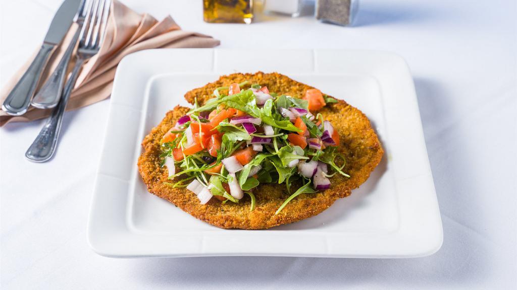 Vitello Milanese · Breaded veal cutlet pen fried topped with chopped tomatoes, onions, and arugula.