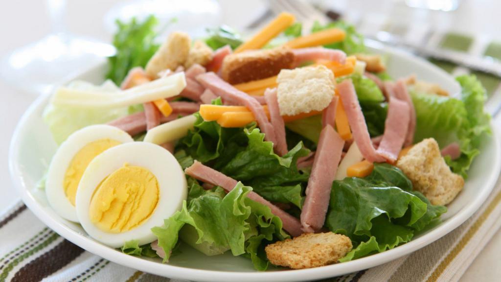Chef Salad · Hearty roast beef, turkey, ham, Swiss cheese, hard-boiled eggs, and locally grown tomatoes and cucumbers on a bed of mixed greens.
