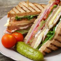 Turkey Club Sandwich · Fresh turkey breast, crispy bacon, and locally grown lettuce and tomatoes with a side of Fre...