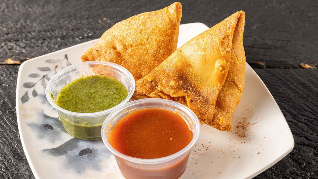 Vegetable Samosa (2 Pieces) · Crispy pastries filled with potatoes, peas and spices. Served with chutney of your choice - cilantro sauce (chutney) or tamarind sauce (chutney).