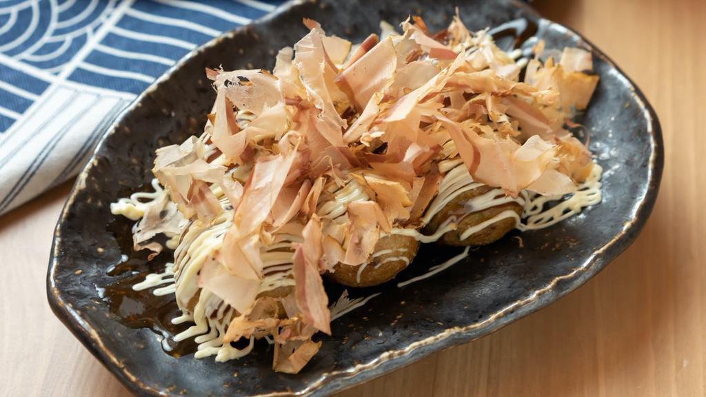 Takoyaki (6 Pieces) · Takoyaki is a ball-shaped Japanese snack made of a wheat flour-based batter and cooked in a special molded pan. It is filled with minced or diced octopus, tempura scraps, pickled ginger, and green onion.