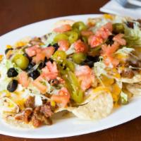 Beef Nachos · Beef chili over tortilla chips, melted monterey jack and cheddar cheese, topped with veggies.
