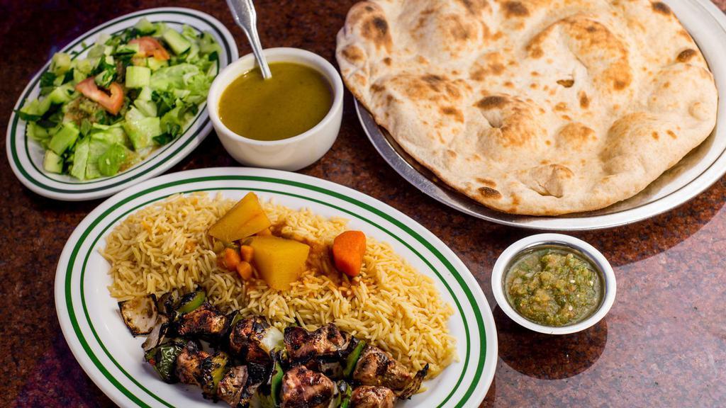 Lamb Shish Kabob · Two skewers of cubed lamb with square onions and peppers grilled on a charcoal flame. Served over a bed of long grain basmati rice and topped with a vegetable sauce. Comes with soup, salad, and bread.
