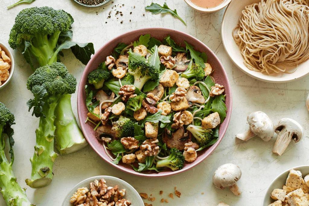 Asian Sesame Ginger · Organic arugula, roasted tofu, roasted mushrooms, roasted broccoli, roasted walnuts, whole wheat noodles and topped with parmesan crisps, served with Asian sesame ginger dressing.