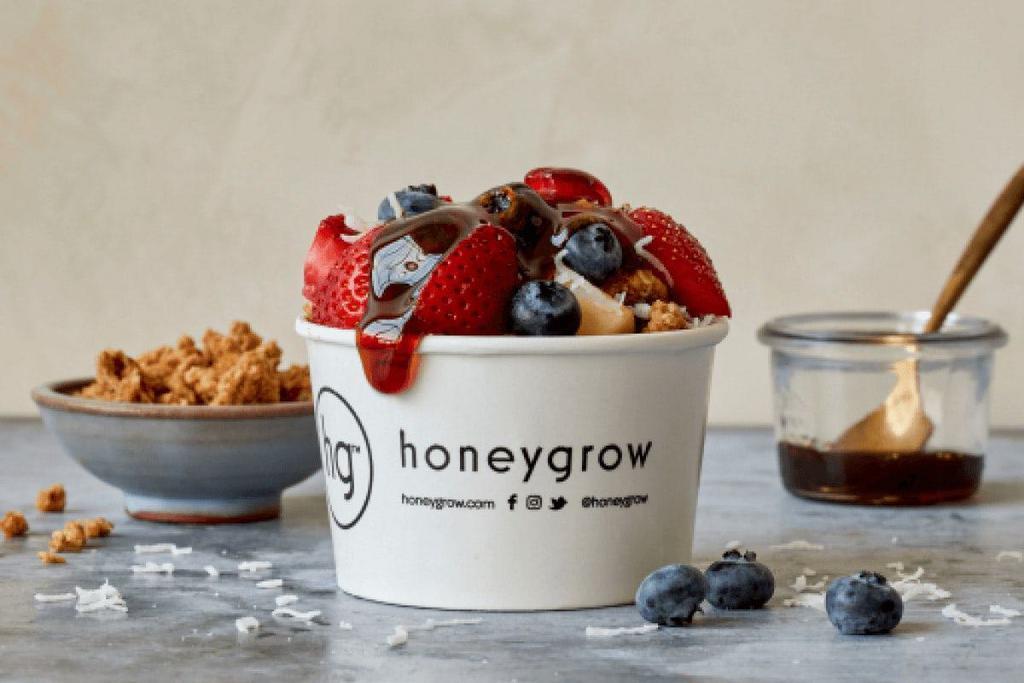 Fruit + Granola · Strawberries, blueberries, apples, grapes, granola, coconut shavings, and our local buckwheat honey.